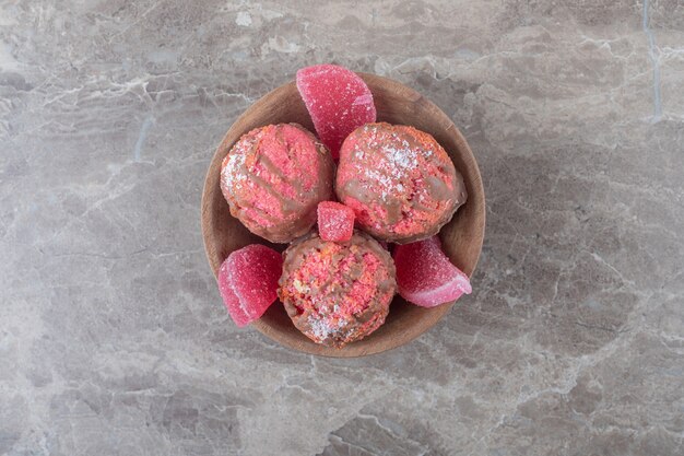 Snack cakes and marmelades in a small bowl on marble surface