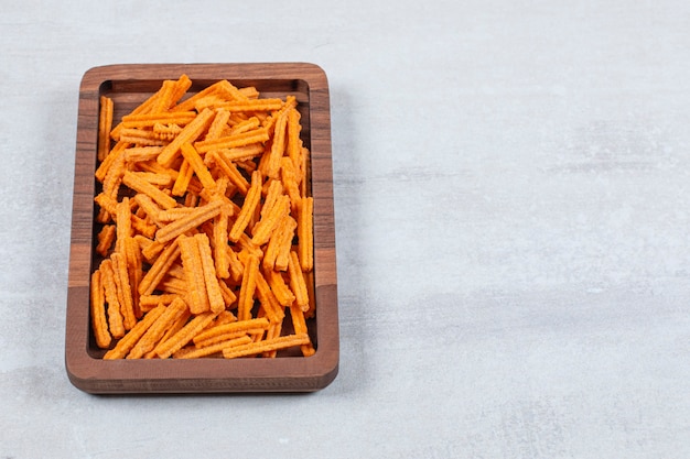 Snack. Fresh chips on wooden plate.