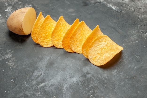 Free photo snack party for friends with delicious homemade chips and potato on gray background