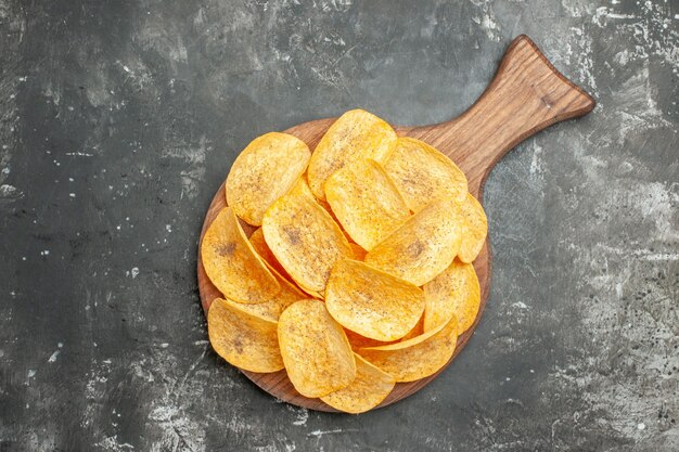 Snack party for friends with delicious homemade chips and potato on gray table