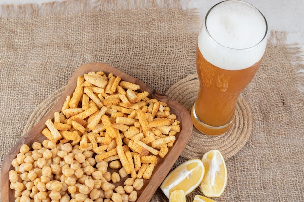 Snack plate, lemon and beer on burlap. 