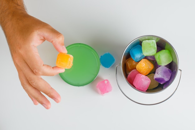 Snack time concept flat lay. hands holding candy.