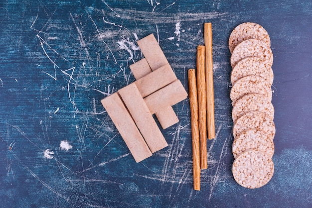 Snacks and crackers on blue space, top view. 