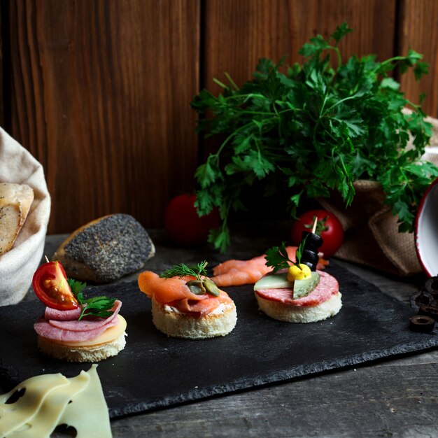 Snacks on sticks with sausage and salmon