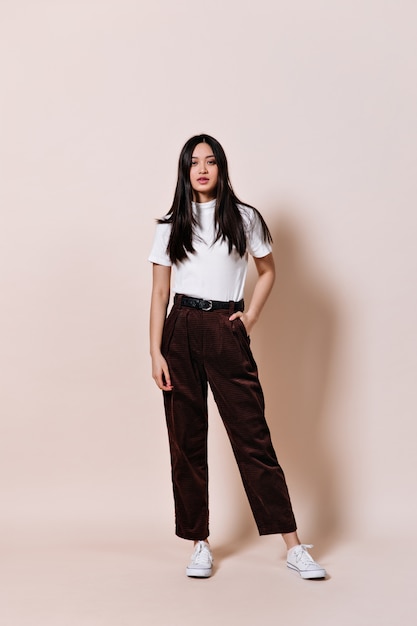 Snapshot of Asian woman in brown pants and white T-shirt