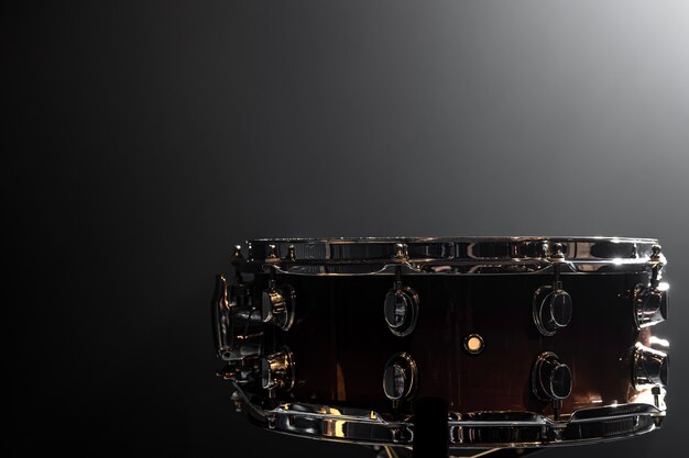 Snare drum, percussion instrument on a dark background with smoke, copy space.