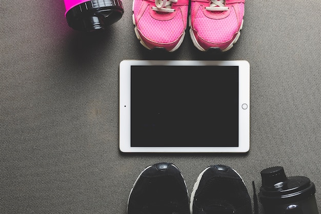 Sneakers and water bottles near tablet