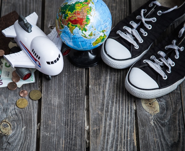 Sneakers, world globe and plane with money