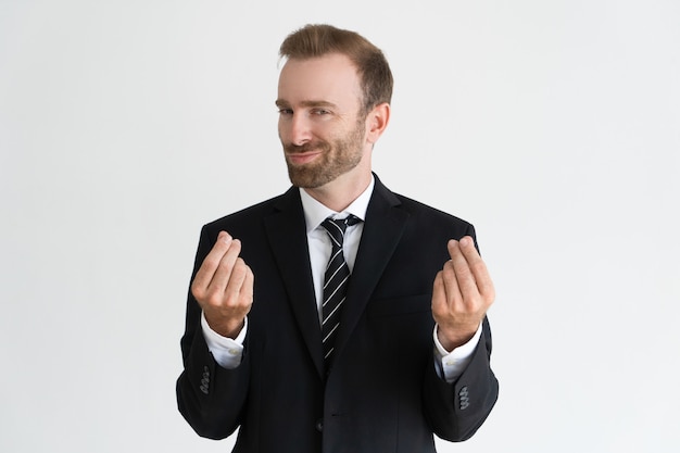 Sneaky business man showing money gesture, asking for money and looking at camera.