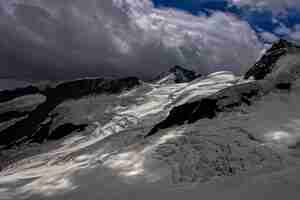 Foto gratuita montagne innevate sotto le nuvole aureola