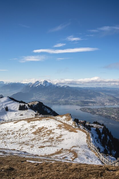 Snow covered view deck with a panoramic view of Rigi Mountain and a Swiss lake under  a blue sky