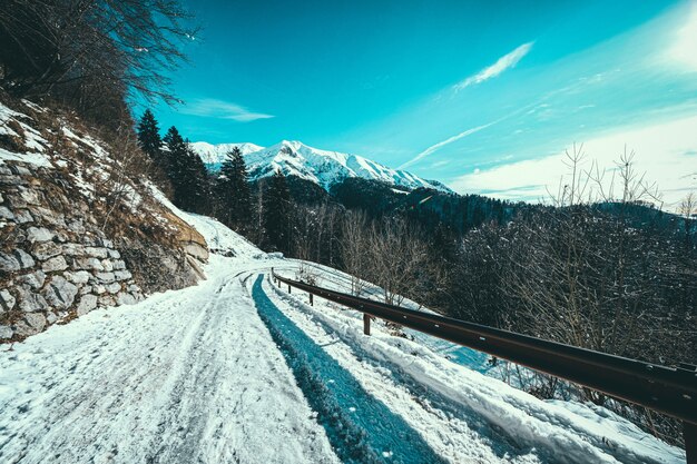 Snow path at the side of a mountain with snow covered mountains