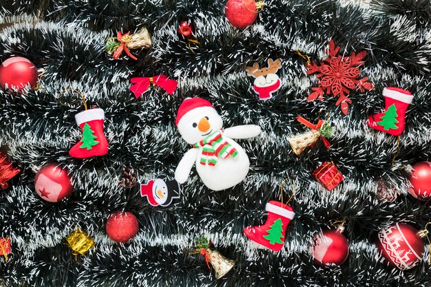 Snowman between Christmas toys on tinsel