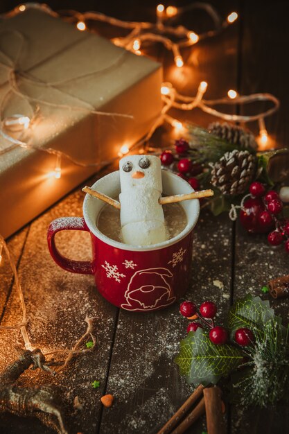 Snowman in the coffee mug on the christmas table