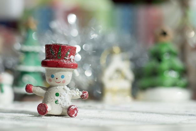 Bambola del pupazzo di neve con l'albero di natale e fondo di natale delle decorazioni del contenitore di regalo