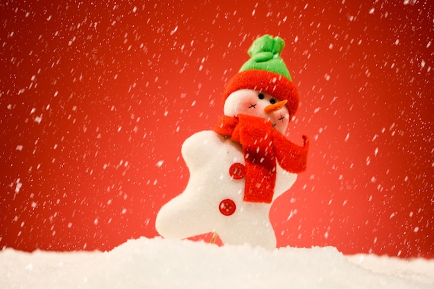 Snowman on snow with red background