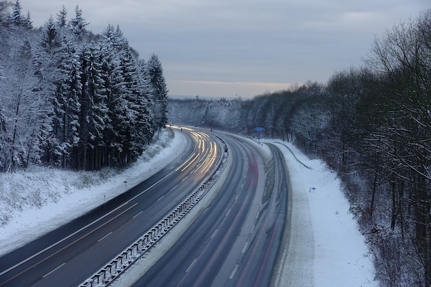 ドイツの夕暮れ時に雪に覆われた高速道路