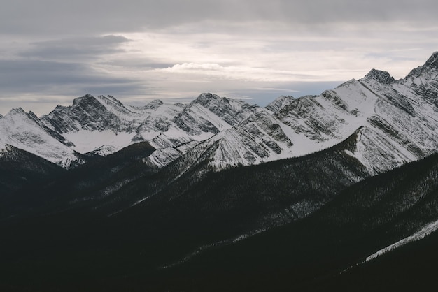 Snowy peaks of rocky mountains under the cloudy sky