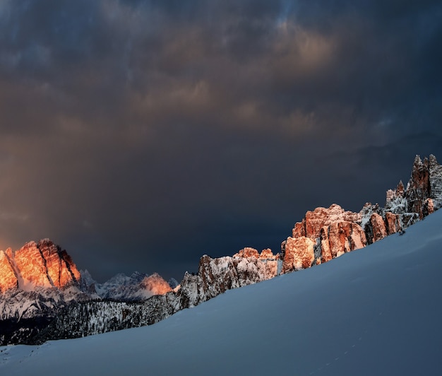 어두운 흐린 하늘 아래 이탈리아 알프스 Dolomiten의 눈 덮인 바위
