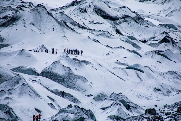 雪に覆われた険しい白い山々とハイキング旅行者