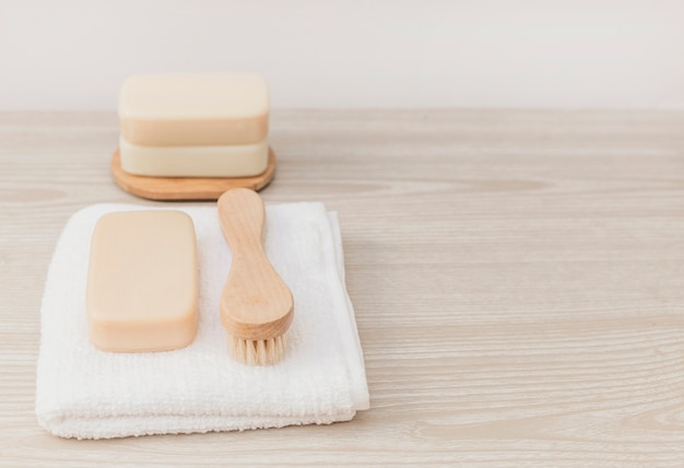 Free photo soap; brush and towel on wooden tabletop