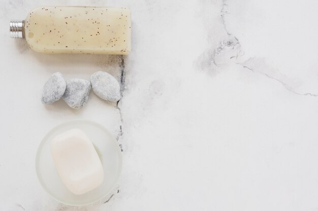 Soap dish and shower gel on marble counter with copy space