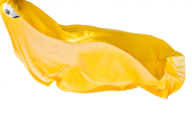 白で隔離または分離されたサッカーボールと滑らかなエレガントな透明な黄色の布