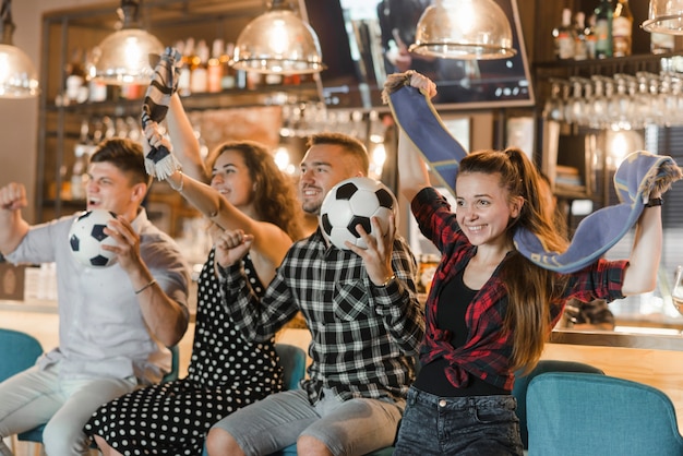 Soccer fans sitting in bar celebrating victory