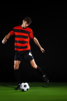 Soccer player kicking ball, playing football
