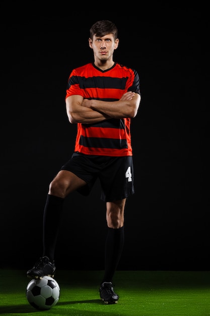 Free photo soccer player staring at green field with ball