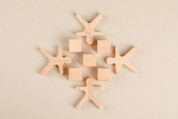 Social distancing concept with wooden cubes and human figures flat lay.