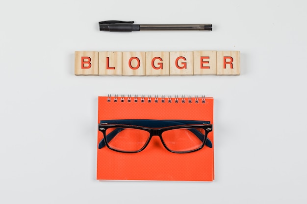 Бесплатное фото Социальные медиа и бизнес-концепция с деревянными блоками, спиральная тетрадь, очки, ручка на белом фоне плоской планировки.