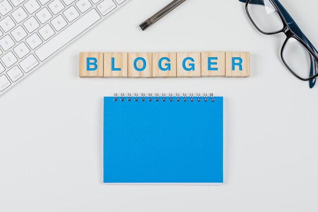 Social media and business concept with wooden blocks, notebook, glasses, pen, keyboard on white background flat lay.