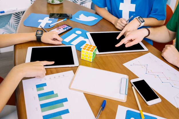 social media team using digital tablet with social media icons on desk