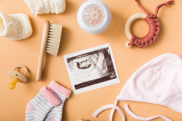 Sock; brush; pacifier; cap; milk bottle and toy on an orange background