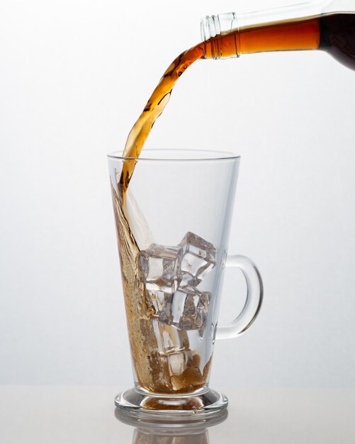 Soft drink pouring into a glass cup