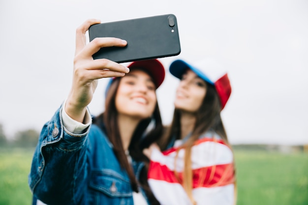 Soft focus of female friends with phone 