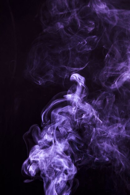 Soft focus of smoke swirling on black background
