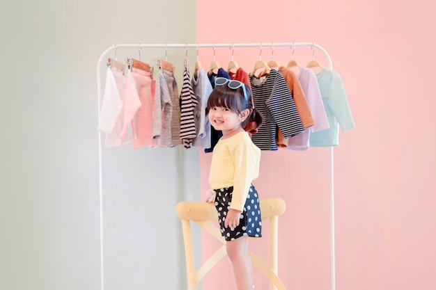 Soft focus of a two years old child standing in front of cloth rack