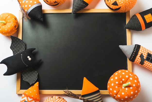 Free photo soft halloween toys around chalkboard