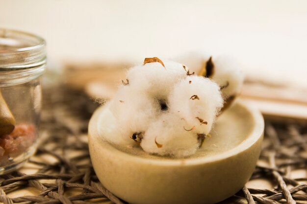 Soft raw cotton ball on marble container