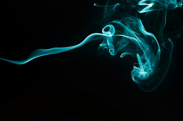 黒の背景に柔らかい青緑色の煙のデザイン