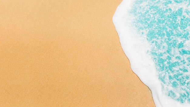 Soft wave of blue ocean on sandy beach.