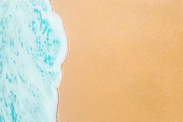 Soft wave of blue ocean on sandy beach.