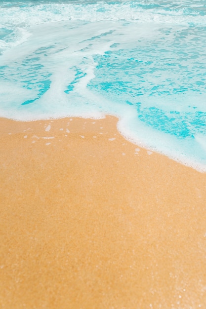 Free photo soft waves with foam blue ocean sea on golden sand with copy space.