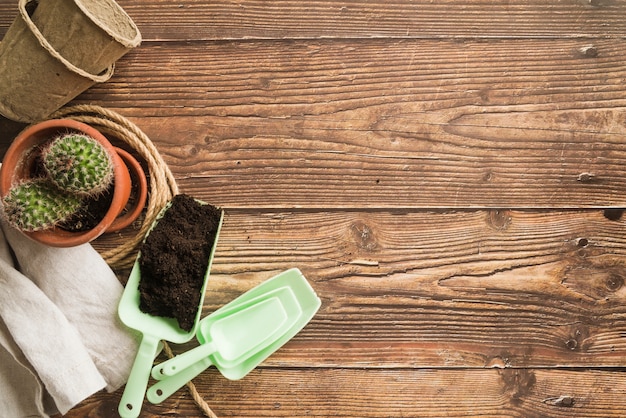 Soil; stacked of potted plant and napkin on wooden desk