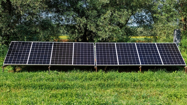 Solar panels on the ground in the nature. Greenery around