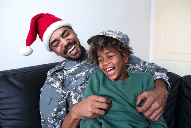 Soldier in military uniform enjoying Christmas holiday with his daughter