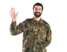 Foto gratuita soldato che saluta sopra priorità bassa bianca