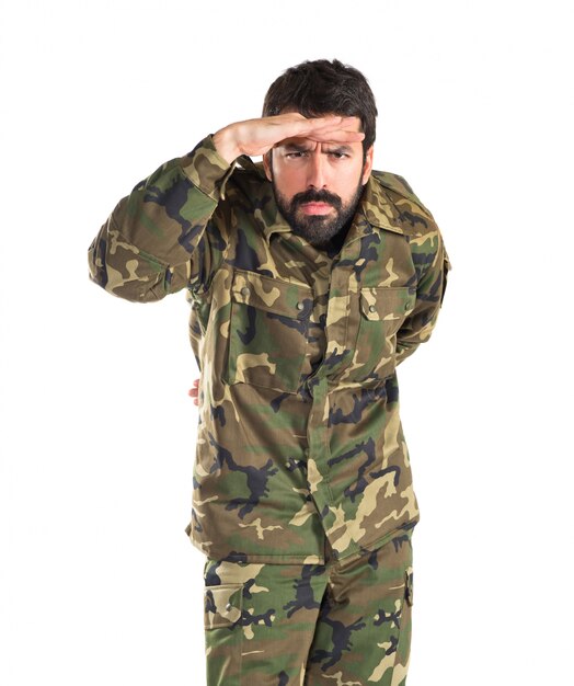 Soldier showing something over white background